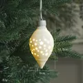 Adorno navideño de cerámica luminosa con recortes de estrellas en una rama de pino - Cono Luminoso de Cerámica