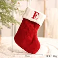 Festliche rote gestrickte Weihnachtssocke mit weißem Umschlag und rotem Buchstaben E - Buchstabe E Stil