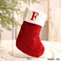 Roter gestrickter Weihnachtsstrumpf mit weißem Rand und gesticktem Buchstaben F - Buchstabe F