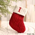 Roter gestrickter Weihnachtsstrumpf mit weißem Aufschlag und rotem Buchstaben I - Buchstabe I Stil