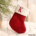 Rote gestrickte Weihnachtssocke mit dem Buchstaben K für die festliche DIY-Dekoration - Buchstabe K Stil