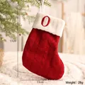 Dekorative rote gestrickte Weihnachtssocke mit weißem Bund und Stickbuchstabe O - Buchstabe O Stil