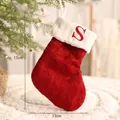 Rote und weiße festliche gestrickte Weihnachtssocke mit besticktem Buchstaben S - Buchstabe S