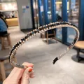 Close-up van een elegante antislip hoofdband met goudkleurige en zwarte strass-kristallen - Zwart