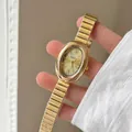 Vista detallada de un elegante reloj de mujer ovalado dorado con correa de metal vintage - Correa de Acero Dorada Esfera Dorada