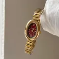 Primer plano de un reloj vintage dorado para mujer con esfera burdeos y números romanos clásicos - Oro con Esfera Roja