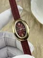 Primer plano de un elegante reloj vintage ovalado para mujer con correa de cuero burdeos - Caja Dorada Correa de Cuero Roja (67787)