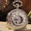 Gros plan d'une montre à gousset mécanique argentée vintage avec des gravures florales - Argent avec cœur argenté