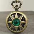 Primer plano de un reloj de bolsillo vintage de bronce con una gema de estrella verde central. - Bronze Green Zirconia
