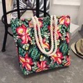 Large floral canvas tote bag with rope handles in vibrant tropical ethnic print. - Green Leaves and Red Flowers
