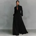 Full-length view of elegant black pleated maxi dress with long sleeves and pockets - Black