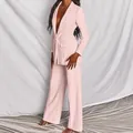 Detalle de un elegante traje de negocios rosa para mujer con blazer y pantalón ancho moderno. - S / Top Y Pantalón / Rosa