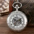 Gros plan d'une montre à gousset squelette argentée avec gravure florale et chiffres romains - Argent