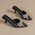 Elegante zwarte muiltjes met spitse neus en een luxe sprankelende strass-strik erop. - 34 / Zwart