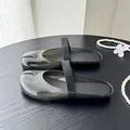 Gros plan de mules noires semi-transparentes à bout fendu avec bride élastique sur table - 35 / Noir