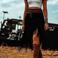 Detailed view of a high-waisted black faux suede fringe skirt with boho tassel movement - S / Bottoms / Black