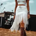 Detailed view of a white high-waist faux suede skirt with long fringe trim. - S / Bottoms / White