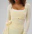 Detail view of the wrap-around tie design and fabric texture of this ballet-style yoga shrug - Light Yellow