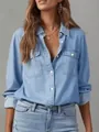 Close-up view of a casual women's long sleeve denim shirt with lapel and chest pockets - Light Blue
