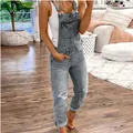 Modische graue Damen-Latzhose mit Destroyed-Effekt in gemütlicher Wohnumgebung - Grau
