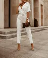 Moderner weißer Jumpsuit mit Reverskragen in einer schicken städtischen Außenanlage. - S / Oben Und Unten / Weiß