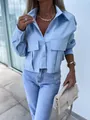 A detailed view of light blue loose batwing sleeve shirt with utility pockets - S / Tops / Blue