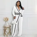 Elegante mono blanco de manga larga con ribete negro en contraste y cinturón ajustable - Blanco
