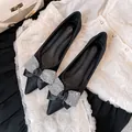 Elegant black pointed-toe flat shoes featuring a decorative sparkling rhinestone bow detail. - 34 / Black