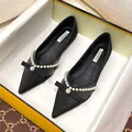 Elegant black pointed-toe flat shoes featuring delicate bow and pearl decorations - 34 / Black