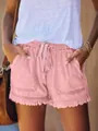 Dettaglio di pantaloncini di jeans rosa a vita alta con elastico e orlo a frange. - Rosa
