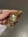 Primer plano del reloj dorado vintage GUOU con números romanos y una elegante correa de metal. - Todo Dorado
