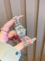 Primer plano detallado de un reloj plateado para mujer con bisel de diamantes - Gris Plata