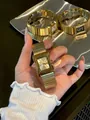 Primer plano detallado del elegante reloj de cuarzo cuadrado GUOU para mujer en dorado - Esfera Oro Champaña / Dorado