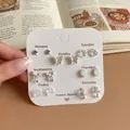 Elegant silver 7-day stud earring set featuring butterfly and bow designs on white card - Laser Butterfly Style (BMW11)