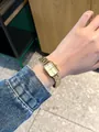 Detailed macro view of IBSO gold rectangular fashion watch on wrist with steel strap - All Gold