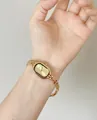 Close-up of an elegant vintage style gold steel watch worn on a woman's wrist - Oval Dial Minimalist Style / Gold Thin Steel Band (3292)