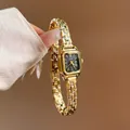 Dettaglio dell'orologio dorato GUOU con quadrante a cifre romane ed elegante - nero oro
