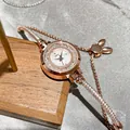 Close-up of rose gold crystal bracelet watch with elegant white dial on wooden stand - Round Dial / Rabbit Slider / Rose Gold White