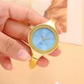 Primo piano di un elegante orologio a bracciale dorato con quadrante blu e punti luce - Braccialetto / Oro e Blu Chiaro