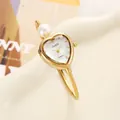 Close-up of elegant heart-shaped gold bangle watch with pearl and CUSSI quartz dial - Gold