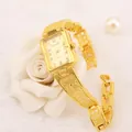 Dettaglio dell'orologio a bracciale dorato Chaoyada da donna su sfondo di rosa bianca - Stile Traforato Farfalla a Pois (WAT00480) / Oro