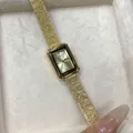 Close-up of golden rectangular Gedi quartz watch with a textured metallic band - All Gold