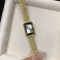 Detailed close-up of a GEDI rectangular gold women's quartz watch in an elegant gift box - Gold White