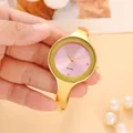 Vista dettagliata di un elegante orologio a bracciale minimalista con quadrante rosa - Braccialetto / Polvere d'oro