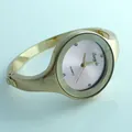 Dettaglio di un orologio da donna a bracciale rigido dorato con quadrante rosa al quarzo - Polvere d'oro