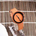 Primo piano di un orologio al quarzo arancione minimalista con cinturino largo e ghiera nera - Arancione