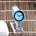 Macro di un orologio di moda azzurro con cinturino a trama intrecciata e lunetta nera. - Celeste