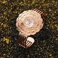 Dettaglio dell'orologio rigido da donna in oro rosa con lunetta a forma di fiore - Oro rosa