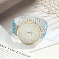 Close-up of floral print elastic band watch with large gold numbers and white dial - Blue