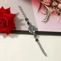 Detailed view of women's silver bracelet watch with black irregular enamel accents - Silver Case Black
